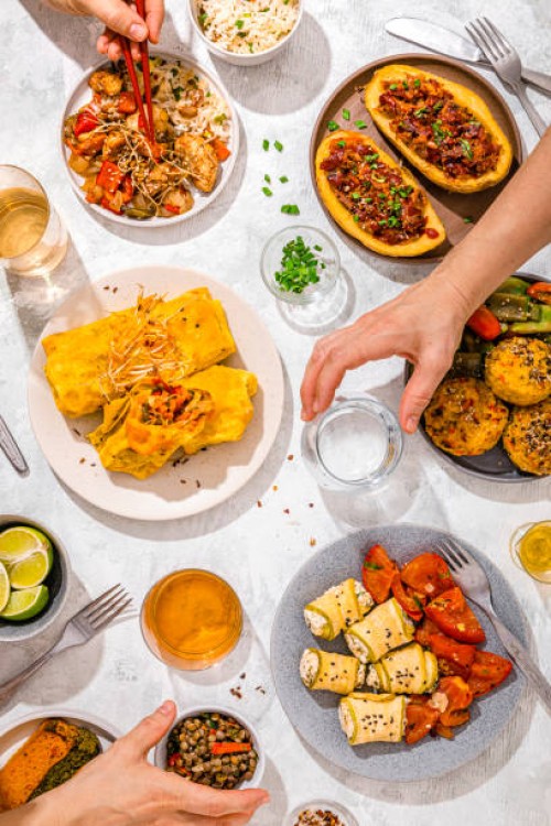 table filled with various dishes including chop suey, stuffed potatoes, fajitas, rice muffins, ricotta rolls and various salads - food stock pictures, royalty-free photos & images