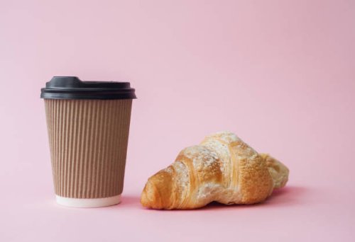 take away coffee in paper cup and croissant over pink background - junk food stock pictures, royalty-free photos & images