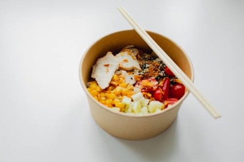 take away food in brown paper craft plate and wooden sticks. chicken, corn, tomatoes, celery and sause. take away delivery. environment protection - junk food stock pictures, royalty-free photos & images