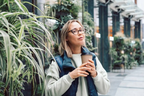 takeaway coffee young woman drinking hot coffee or tea from paper coffee cup outdoors - junk food stock pictures, royalty-free photos & images