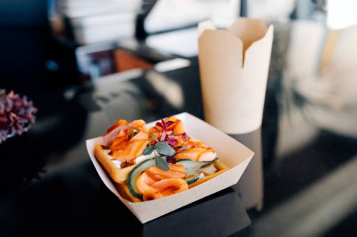 takeout treat: savory smoked salmon waffles and stir-fried noodles in paper containers - junk food stock pictures, royalty-free photos & images