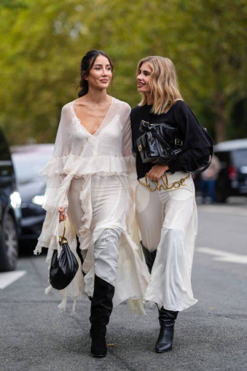 Tamara Kalinic white flowy ruffled long sleeve Chloe midi dress, black leather Chloe bag, black heeled thigh high Chloe boots. Xenia Adonts wears...