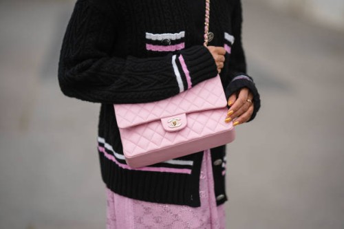 Tamu McPherson wears a black with white and pink embroidered white and pink striped borders pattern buttoned jacket from Chanel, a pale pink shiny...
