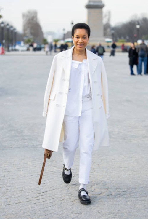 Tamu McPherson wears white coat, pants, shirt, brown bag outside Dior during the Womenswear Fall/Winter 2025/2026 as part of Paris Fashion Week on...