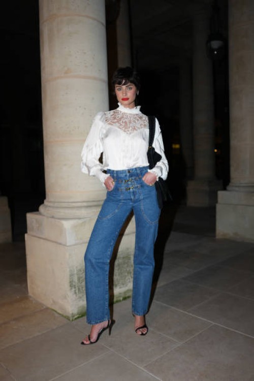 Taylor Hill wears dark brown pixie hair cut, bright cherry red lipstick, shiny sheer mesh lace long sleeve high neck Isabel Marant top, black Isabel...