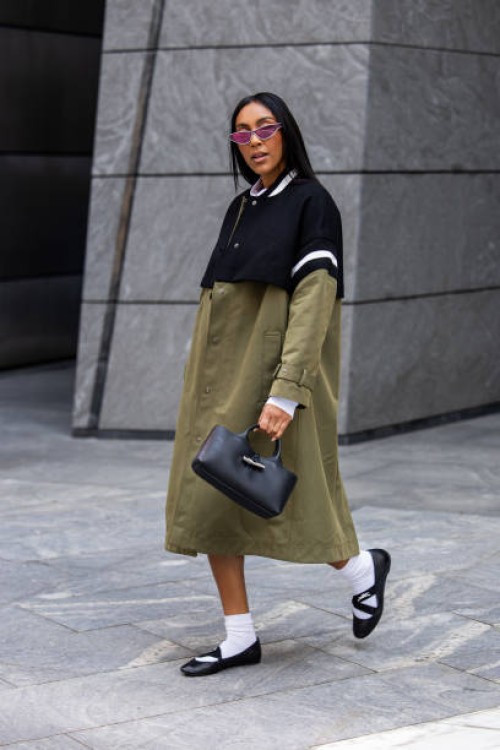 Tayshia Adams wears Longchamp green black coat, bag, shoes during New York Fashion Week on September 09, 2024 in New York City.