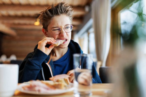 teenage boy eating a very tough sandwich - junk food stock pictures, royalty-free photos & images