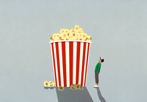 teenage boy looking up at large movie theater popcorn tub - junk food stock illustrations