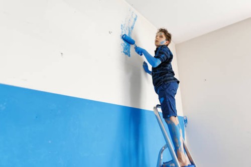 teenage boy making mistake while painting the room - home decoration stockfoto's en -beelden