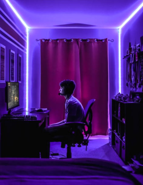 teenage boy playing video game at desk in room with neon led lighting. - home decoration stock pictures, royalty-free photos & images