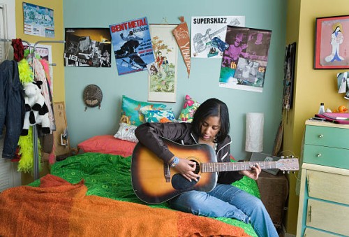 teenage girl (15-17) playing acoustic guitar on bed - home decoration stock pictures, royalty-free photos & images