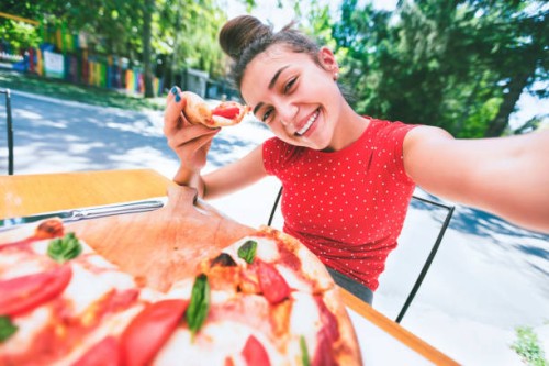 teenage girl taking a selfie while eating pizza - food stock pictures, royalty-free photos & images