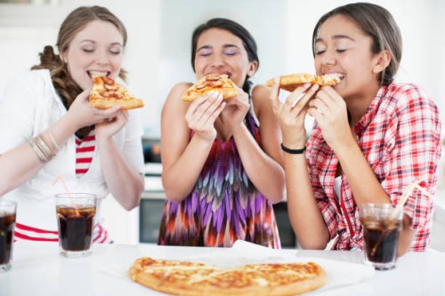 teenage girls eating pizza - junk food stock pictures, royalty-free photos & images
