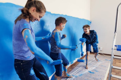 teenage kids having fun painting the room - home decoration stockfoto's en -beelden