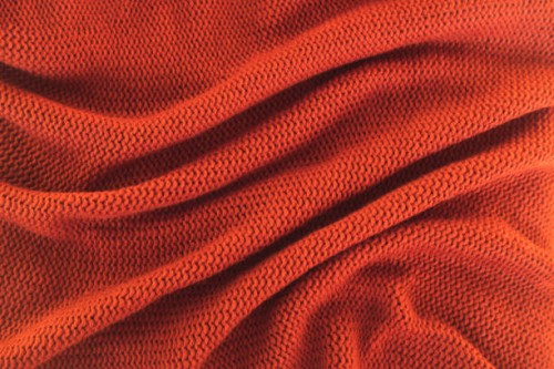 texture of knitted red sweater folded in a swirling pattern. flat lay style, close-up. - fashion stock pictures, royalty-free photos & images