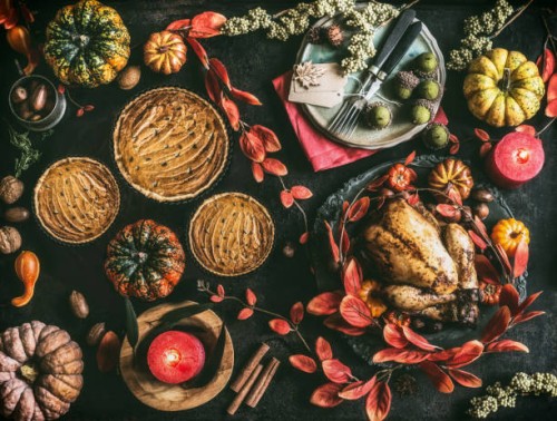 thanksgiving day dinner table with pumpkin pie, roasted turkey and festive autumn decoration and candles - home decoration stock pictures, royalty-free photos & images