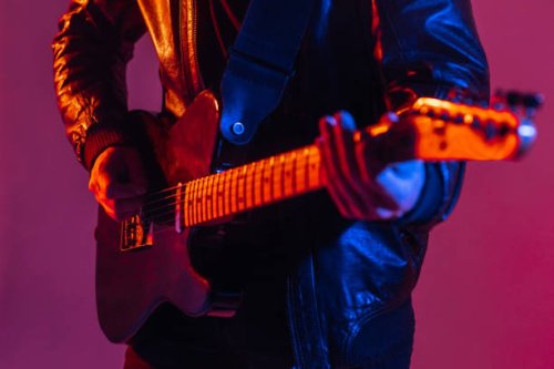 the guitar is close -up in the light of neon. unrecognizable man guitarist plays music on a musical instrument - concert stock pictures, royalty-free photos & images