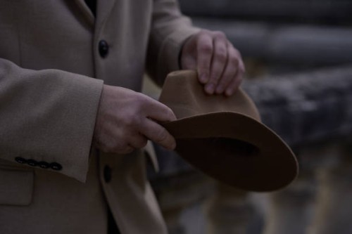 the hands of a handsome man with a beige fashionable hat. a man in a historical costume of the 30s -40s of the 20th century, in a beige coat and a black turtleneck holds a hat in his hands. - fashion stock pictures, royalty-f