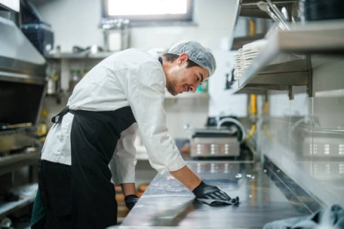 the restaurant chef is wiping down the kitchen counter. - food stock pictures, royalty-free photos & images