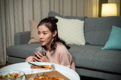 the young lady at home eating take-away - junk food stock pictures, royalty-free photos & images