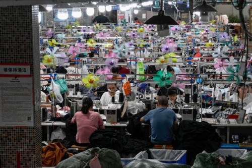 This photo taken on June 11, 2024 shows workers producing garments at a textile factory that supplies clothes to fast fashion e-commerce company...