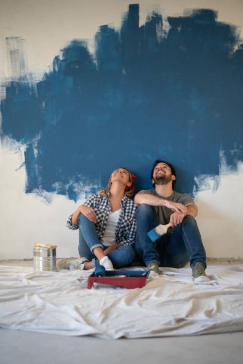 thoughtful couple taking a break from painting their house - home decoration stock pictures, royalty-free photos & images