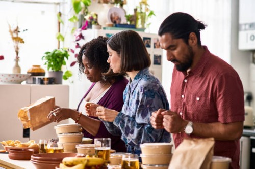 three friends serving takeaway food from delivery - junk food stock pictures, royalty-free photos & images