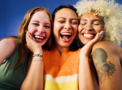 three gen z women laughing together on blue background - fashion stock pictures, royalty-free photos & images