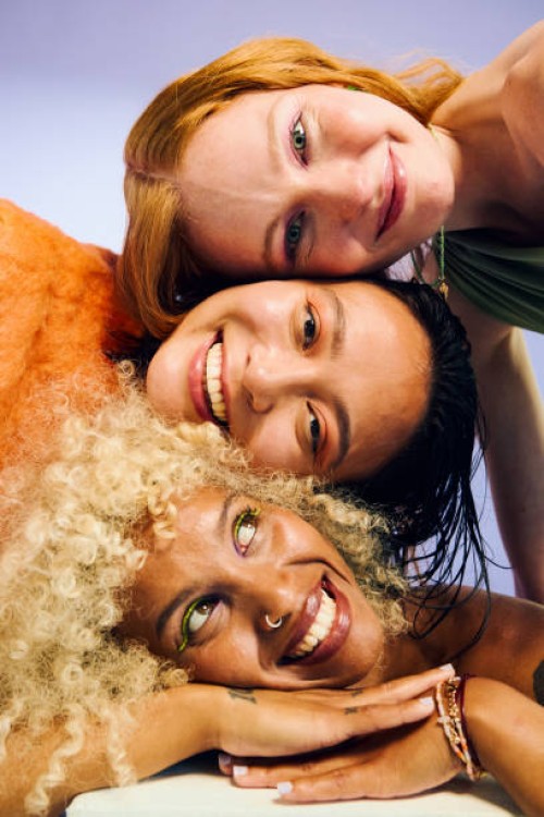 three smiling gen z women resting heads together, embracing wellness and friendship - fashion stock pictures, royalty-free photos & images