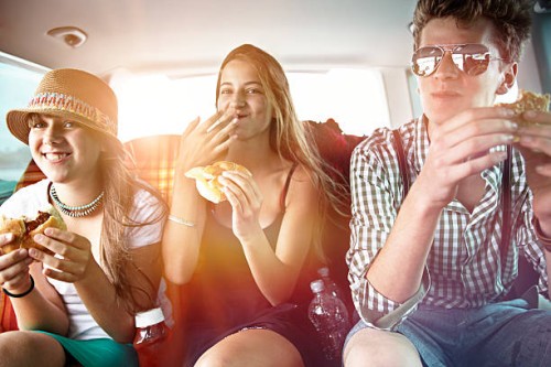 three teenage friends having a snack in car - food stock pictures, royalty-free photos & images