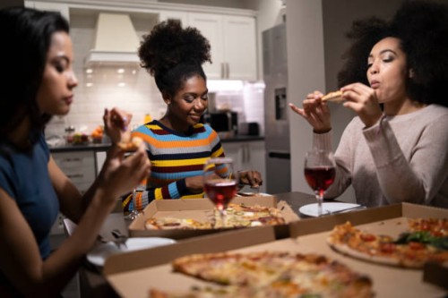 three young beautiful multi-ethnic women having fun at home party - junk food stock pictures, royalty-free photos & images