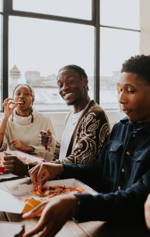 three young people share a pizza together - junk food stock pictures, royalty-free photos & images