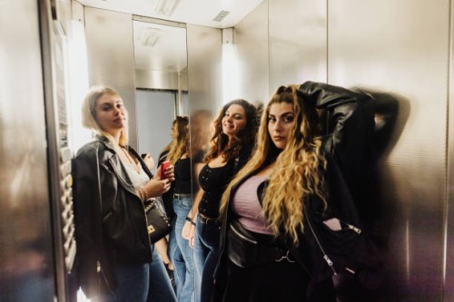three young women in elevator - fashion stock pictures, royalty-free photos & images