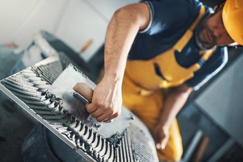 tile handyman applying adhesive on a tile. - home decoration stock pictures, royalty-free photos & images