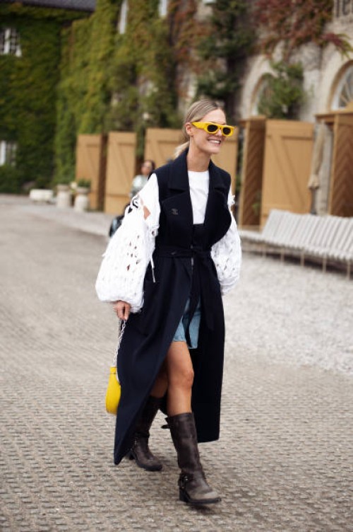 Tin Vcb wears a navy sleeveless coat, denim shorts and a white laced top outside Munthe during the Copenhagen Fashion Week Spring/Summer 2024 on...