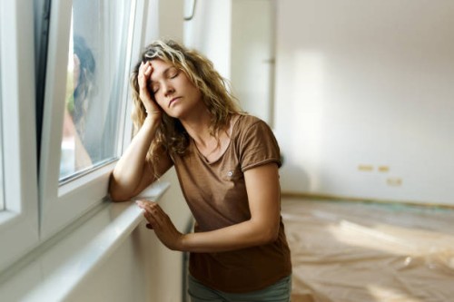 tired woman by the window in her new apartment. - home decoration stock pictures, royalty-free photos & images