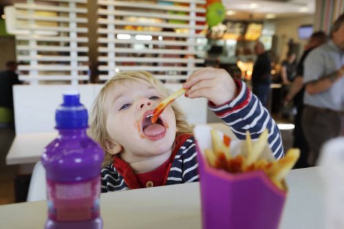 toddler eating fast food in restaurant - junk food stock pictures, royalty-free photos & images