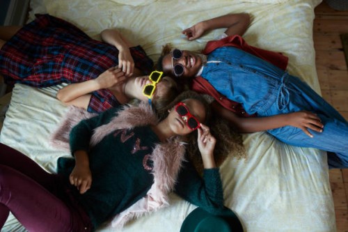 top view of girlfriends relaxing in bed and wearing weird glasses - fashion stock pictures, royalty-free photos & images