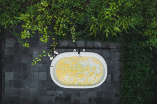 top view of outside bath tub full of yellow flowers in tropical spa. luxury interior. - garden decoration stock pictures, royalty-free photos & images