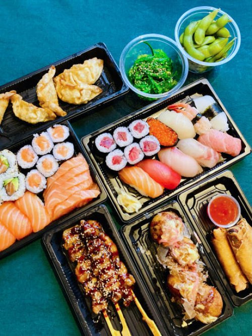 top view of quality sushi and sashimi set takeaway with japanese side dishes on table laid with tablecloth - junk food stock pictures, royalty-free photos & images