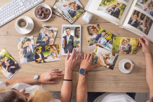 top view of wedding pictures collection on a table, viewed by a couple having coffee and biscuits. - home decoration stock pictures, royalty-free photos & images