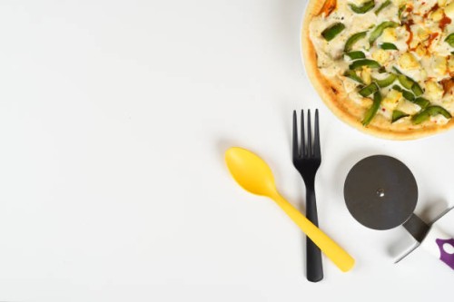 top view white desk with pizza, spoon, fork, pizza cutter on white background copy space - junk food stock pictures, royalty-free photos & images