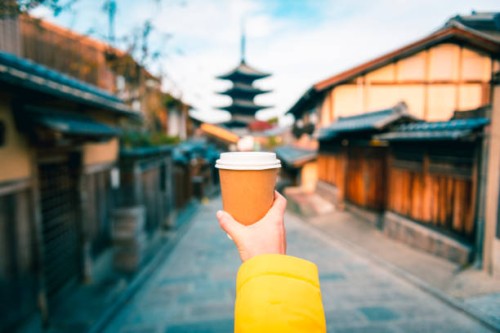 tourist holding a coffee paper cup in higashiyama district, kyoto, japan - junk food stock pictures, royalty-free photos & images