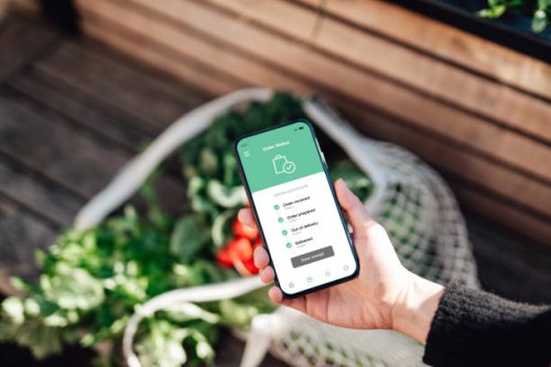 tracking online food and grocery delivery via mobile app on smart phone - food stock pictures, royalty-free photos & images