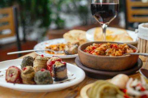 traditional georgian cuisine. vegetarian chashushuli with mushrooms, phali - snack made of nuts, various vegetables or herbs and spices and eggplant rolls, pickled vegetables, and a glass of red wine. - food stock pictures,