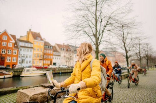 travel guide and her group on the bicycles through the town - travel stock pictures, royalty-free photos & images