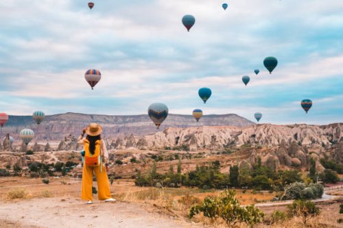 traveler backpacker girl is watching hot air balloons and the fairy chimneys at cappadocia goreme in nevsehir , turkey - travel stock pictures, royalty-free photos & images