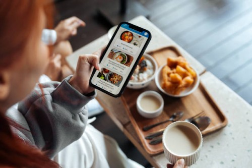 traveler gen z using a food delivery app on a smartphone - food stock pictures, royalty-free photos & images