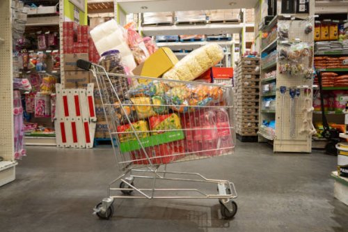 trolley filled with groceries in wholesale store landscape - junk food stock pictures, royalty-free photos & images