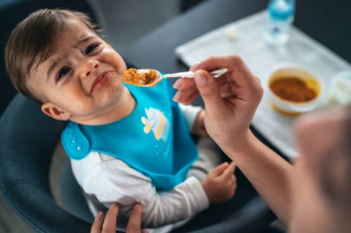 trying to feed a baby boy - food stock pictures, royalty-free photos & images